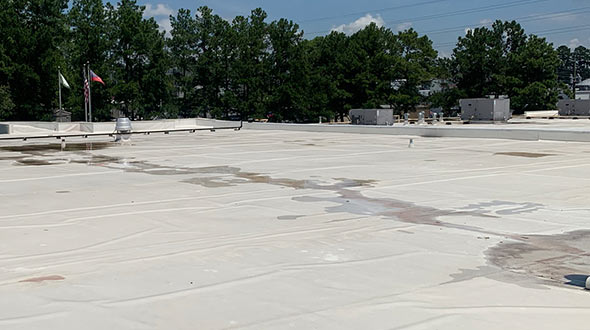 Commercial flat roof inspection of water pooling and penetration damages