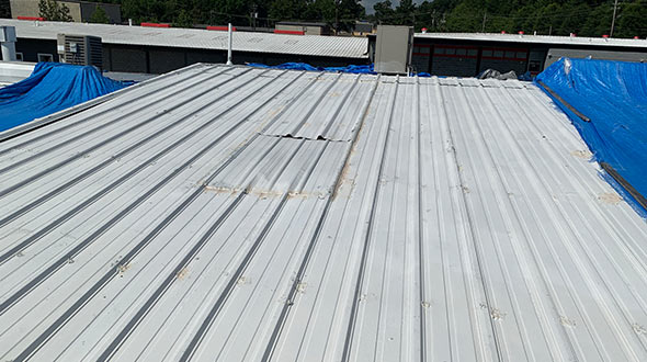 Commercial metal roof with corrosion and damaged seals