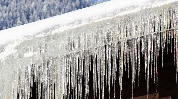 Ice dam freezing water damaging a commercial roof