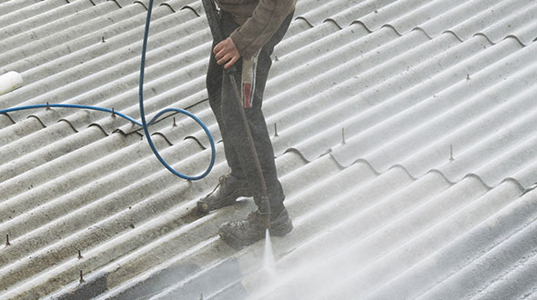 Commercial roof power washing before protective coating application